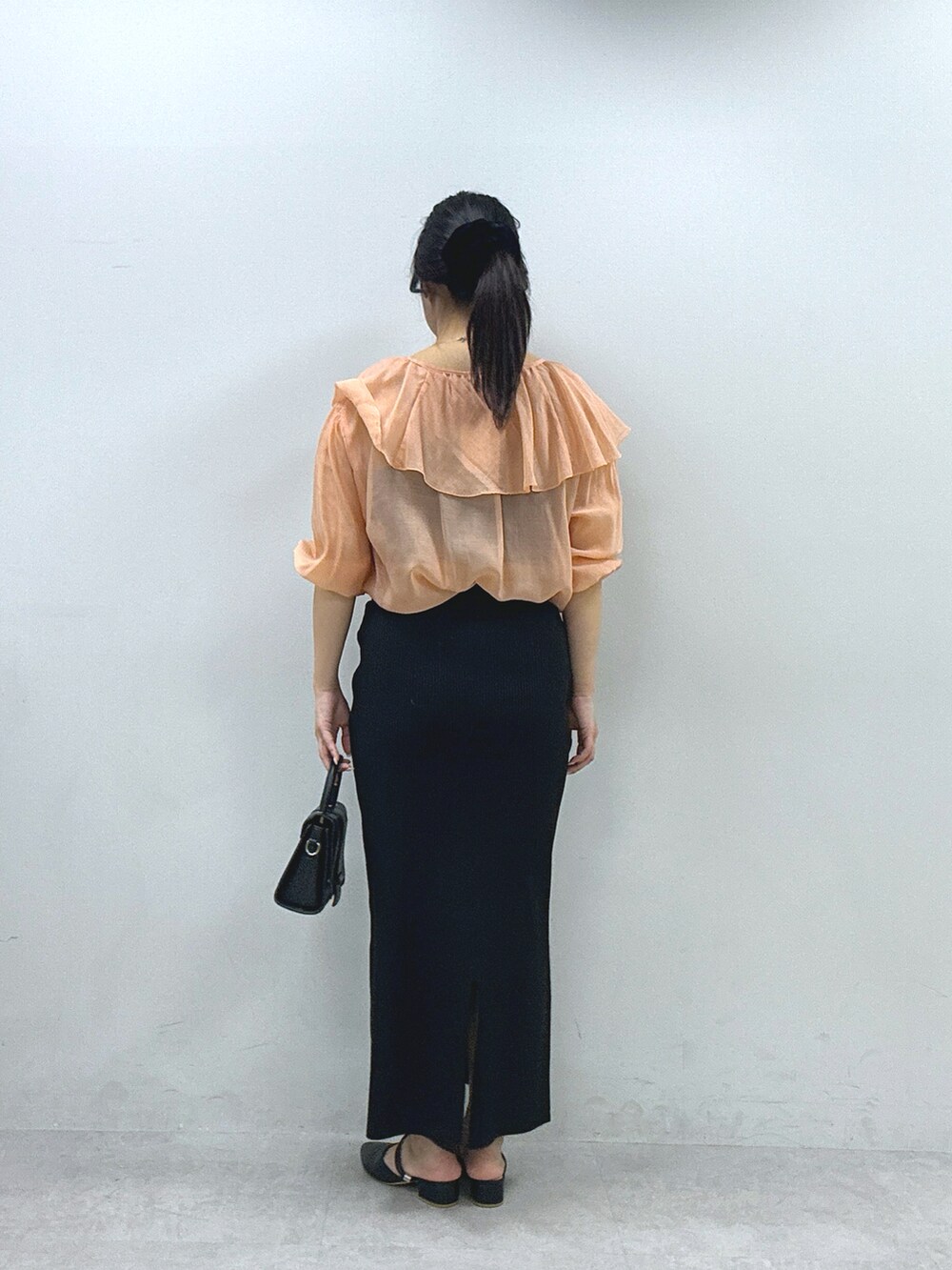 オレンジ系のシャツ/ブラウス、ブラック系のスカートを着用したレディースの春コーディネートの3枚目の写真
