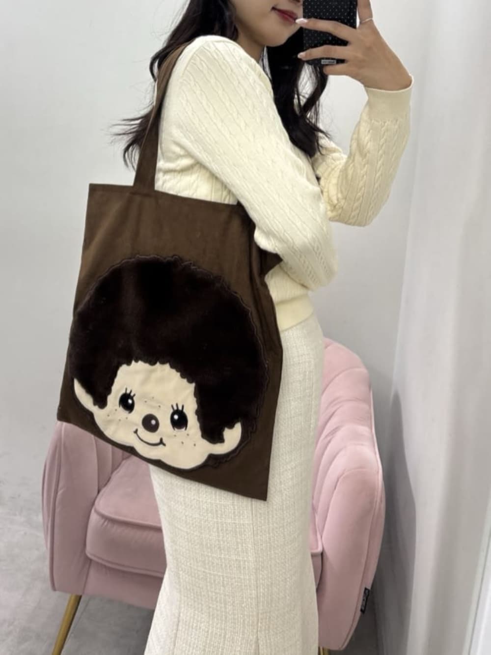 ホワイト系のスカート、ブラウン系のトートバッグ、ホワイト系のニット/セーターを着用したレディースの冬コーディネートの5枚目の写真