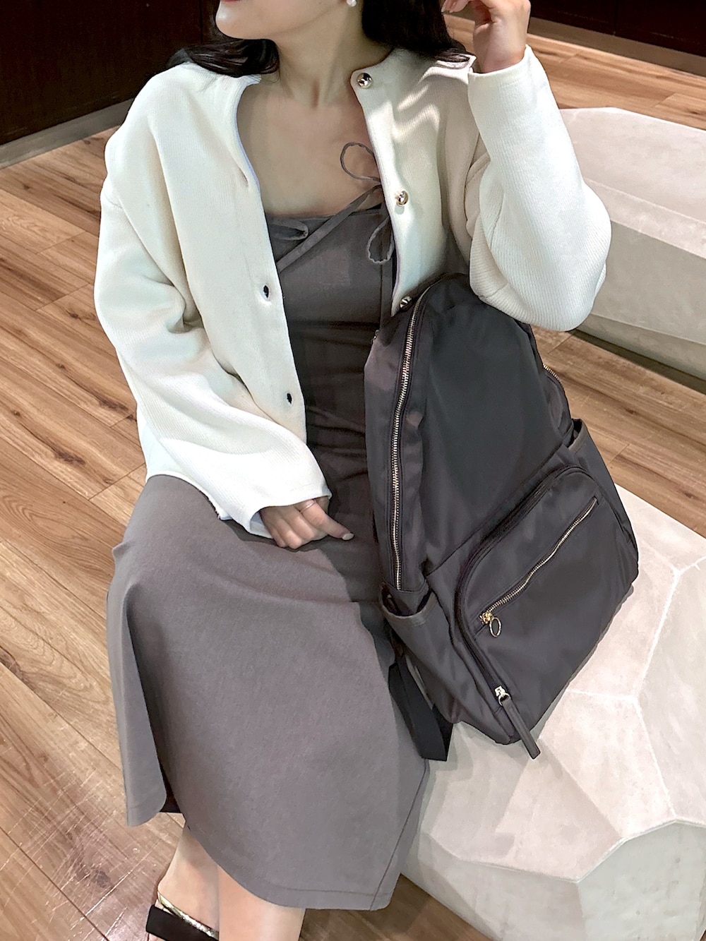 グレー系のワンピース、ホワイト系のカーディガン/ボレロを着用したレディースの春コーディネートの4枚目の写真