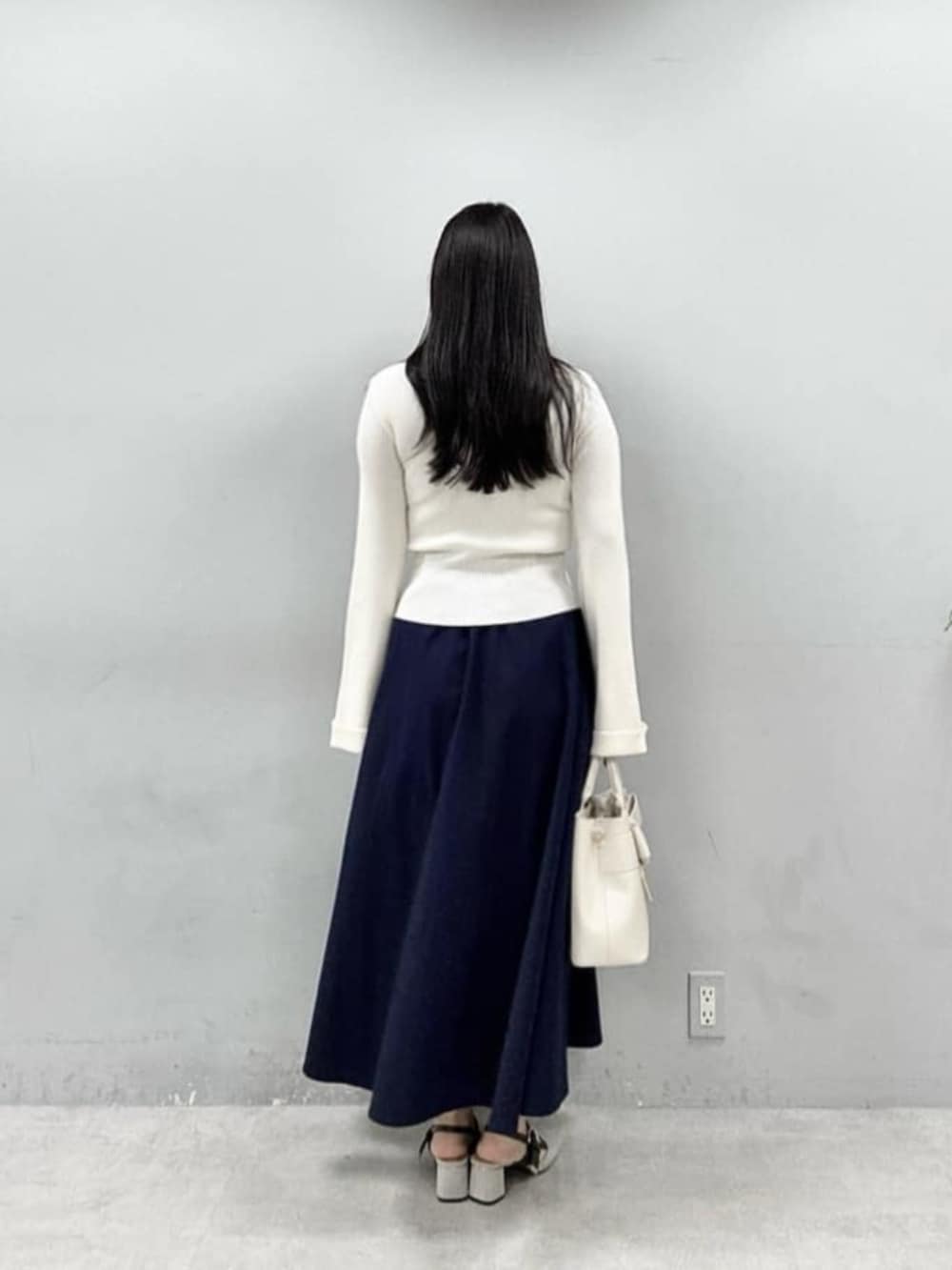 ホワイト系のショルダーバッグ、ホワイト系のニット/セーターを着用したレディースの春コーディネートの3枚目の写真