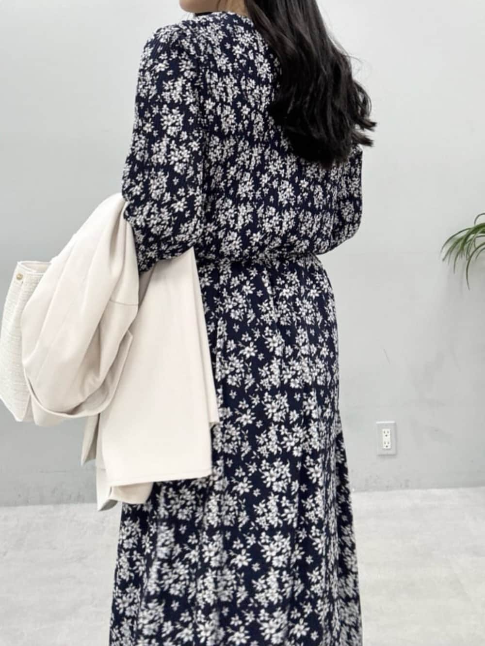 ホワイト系のテーラードジャケット、ホワイト系のハンドバッグ、グレー系のサンダルを着用したレディースの冬コーディネートの9枚目の写真