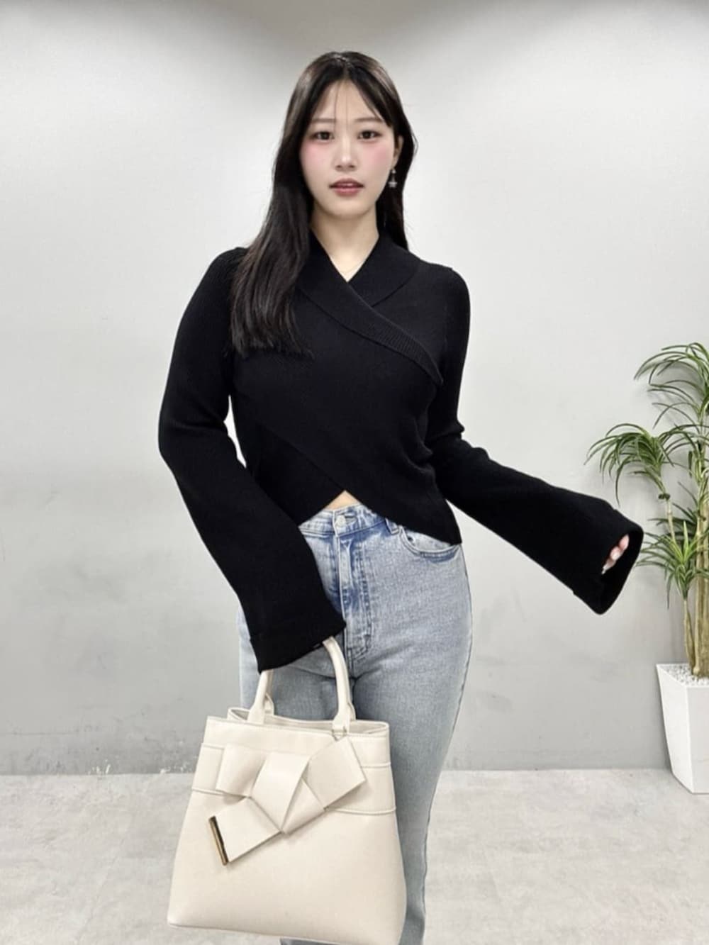 ブルー系のデニムパンツ、ブラック系のニット/セーターを着用したレディースの春コーディネートの3枚目の写真