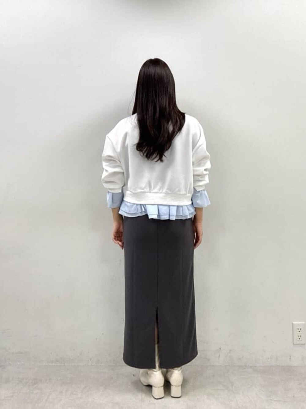グレー系のワンピース、ホワイト系のスウェットを着用したレディースの冬コーディネートの3枚目の写真