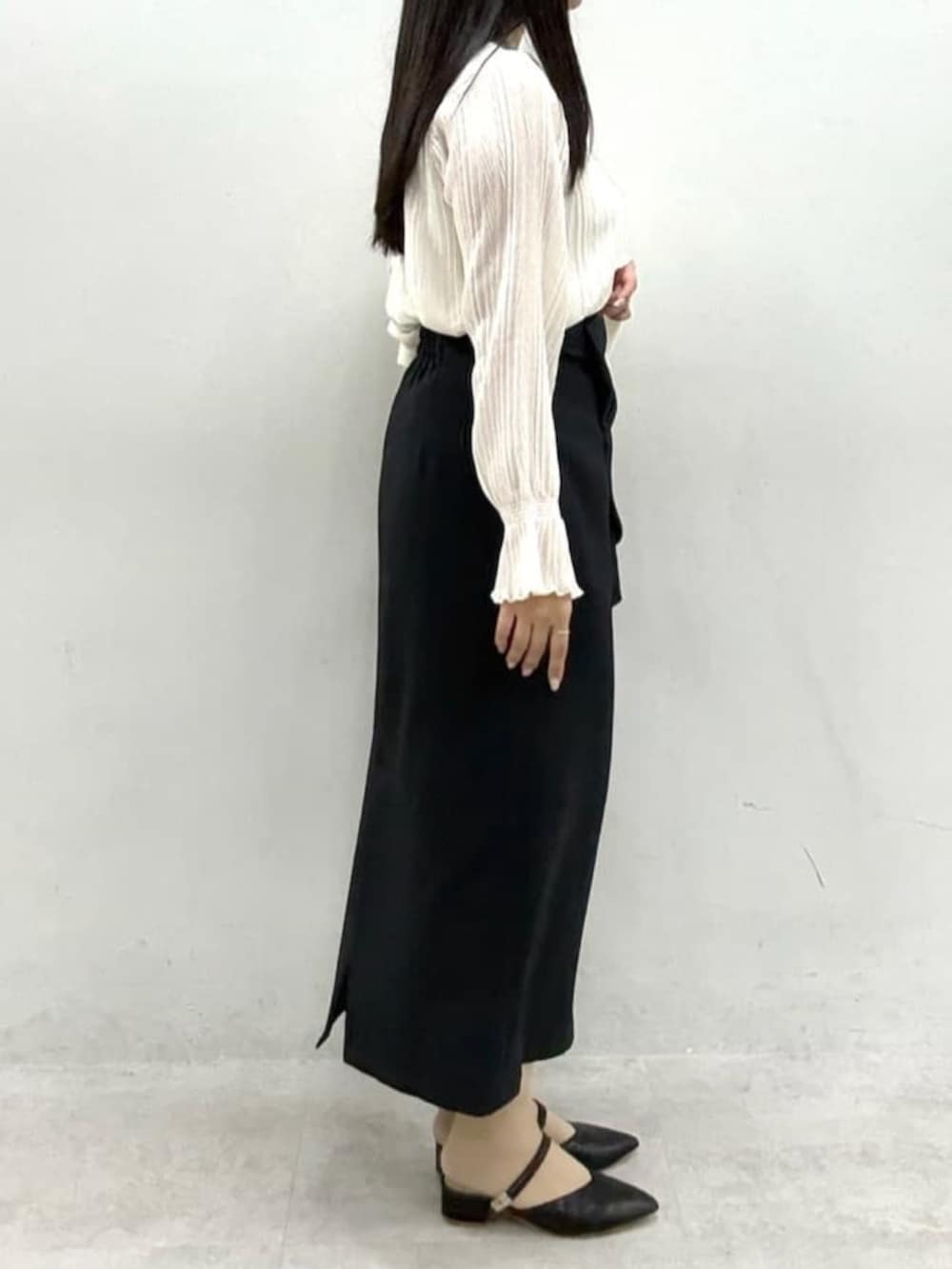 ブラック系のスカート、ホワイト系のノーカラージャケット、ホワイト系のシャツ/ブラウスを着用したレディースの冬コーディネートの5枚目の写真