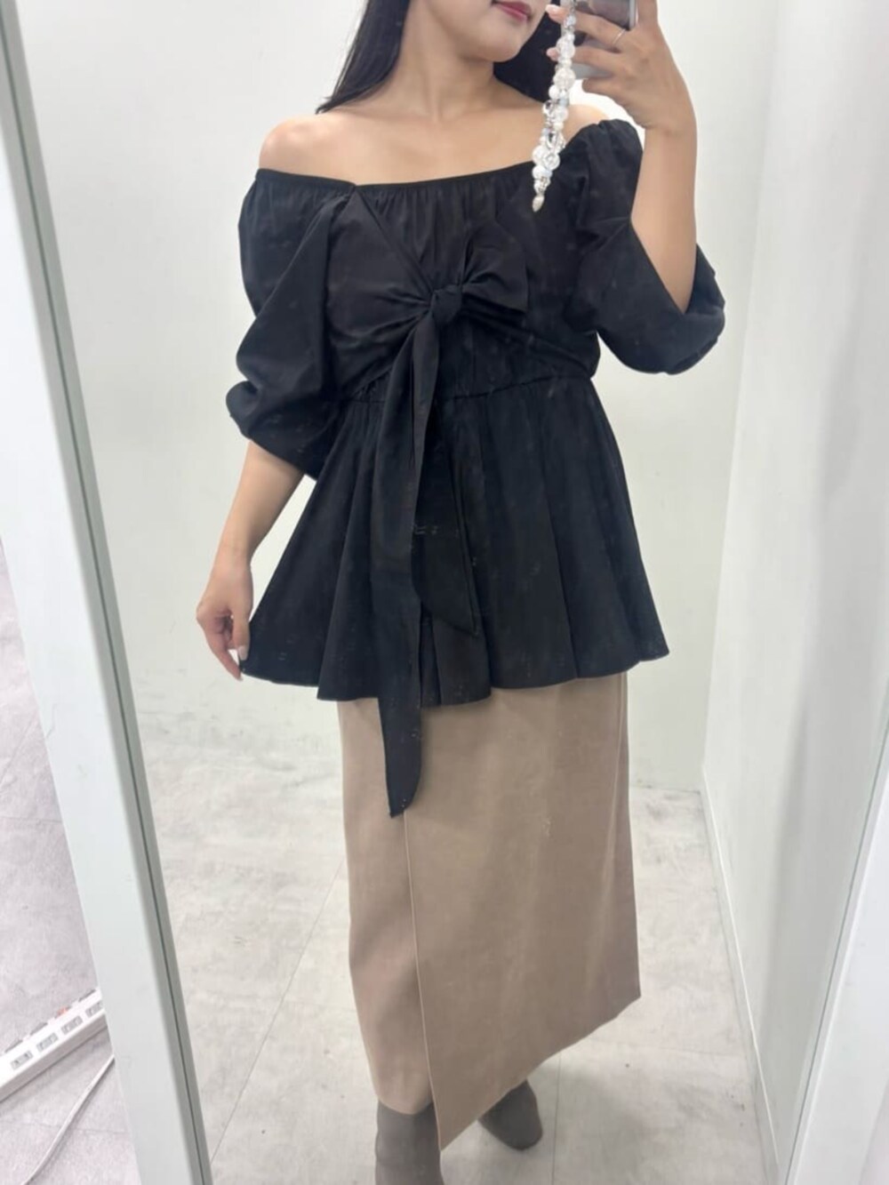 ブラウン系のスカート、ブラック系のシャツ/ブラウスを着用したレディースの秋コーディネートの4枚目の写真