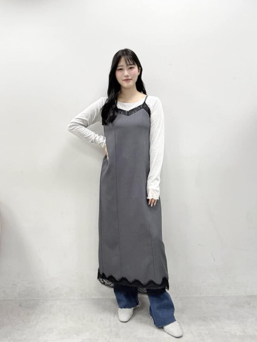 ホワイト系のテーラードジャケット、ホワイト系のハンドバッグ、グレー系のサンダルを着用したレディースの冬コーディネートの2枚目の写真