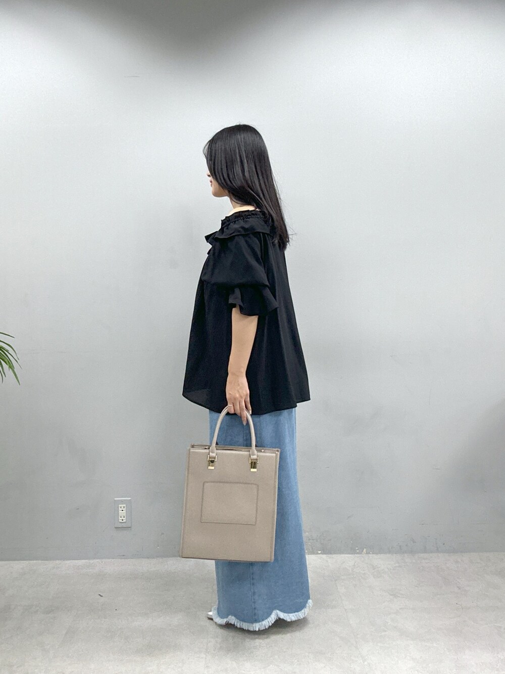 ベージュ系のショルダーバッグ、ブラック系のシャツ/ブラウス、ブルー系のスカートを着用したレディースの春コーディネートの2枚目の写真