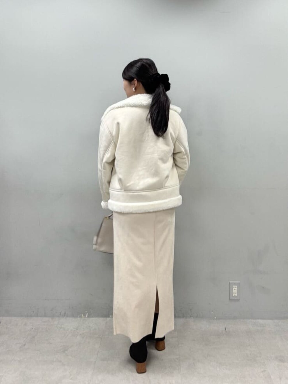 グレー系のシャツ/ブラウス、ベージュ系のスカート、ホワイト系のブルゾンを着用したレディースの秋コーディネートの3枚目の写真