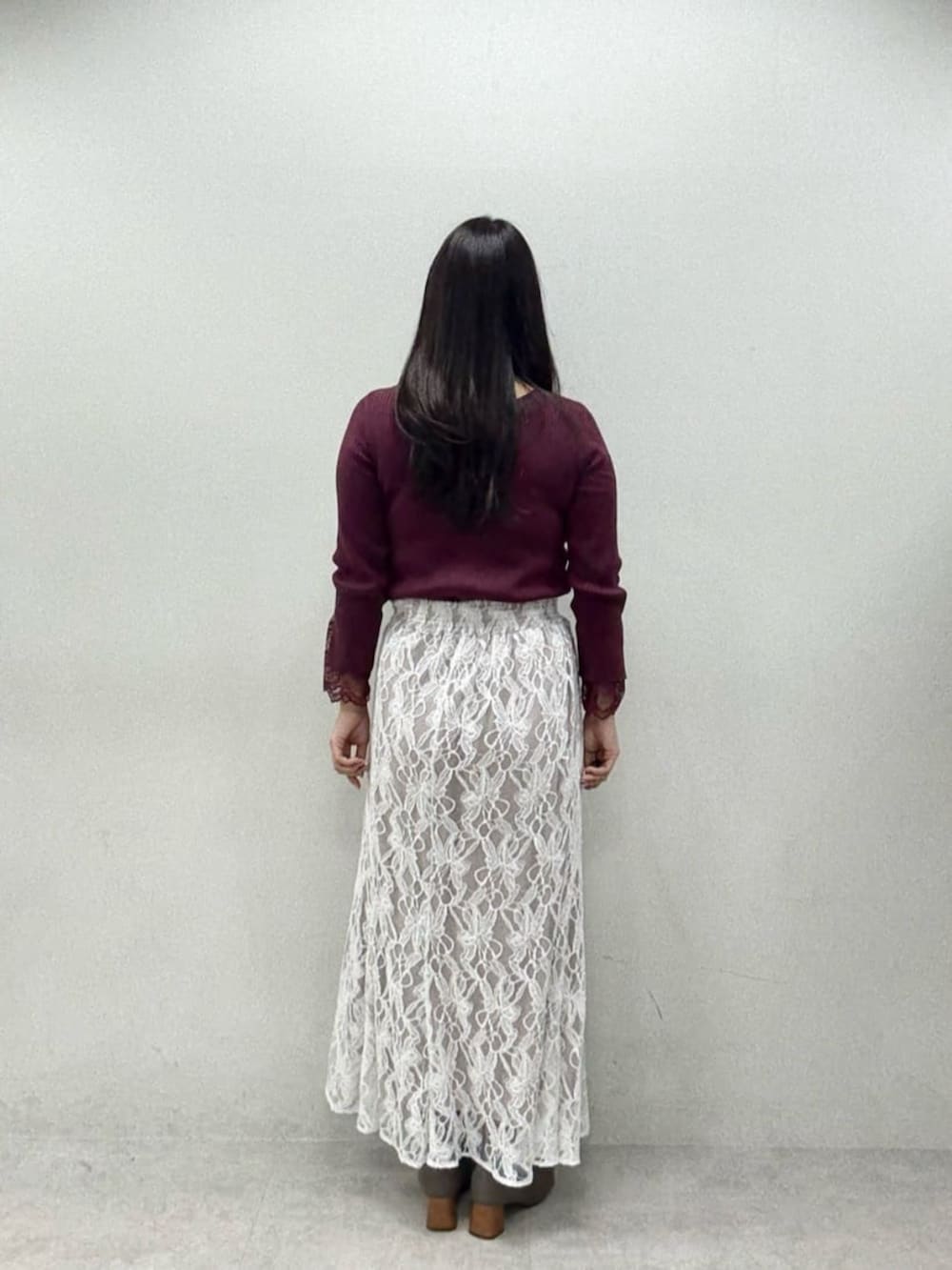 レッド系のニット/セーター、ホワイト系のスカートを着用したレディースの秋コーディネートの3枚目の写真