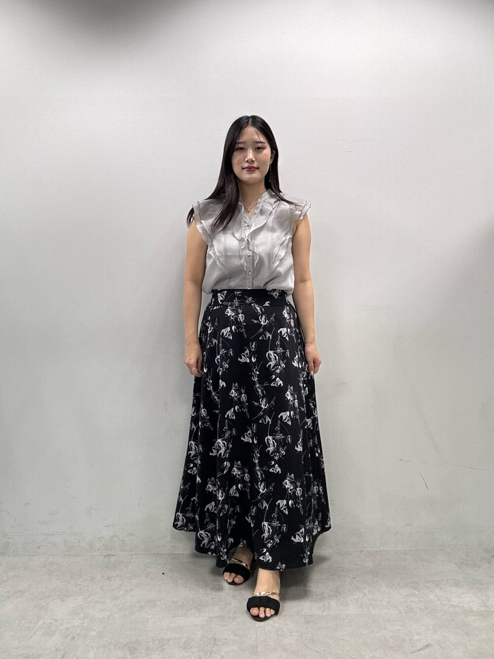 ホワイト系のカーディガン/ボレロ、ブラック系のスカート、グレー系のシャツ/ブラウスを着用したレディースの春コーディネートの2枚目の写真