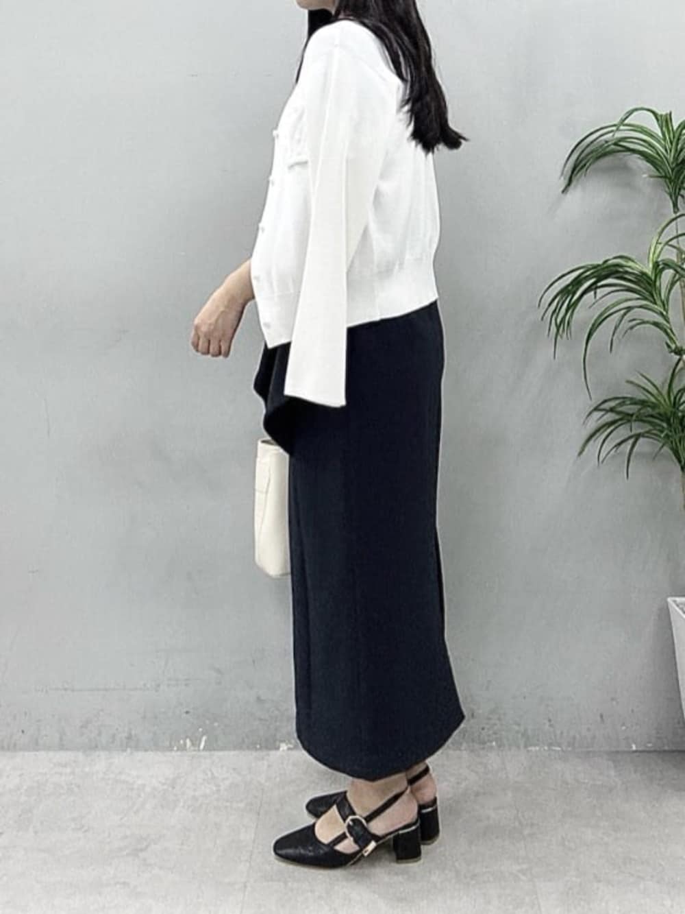 ブラック系のスカート、ホワイト系のカーディガン/ボレロ、ブルー系のシャツ/ブラウスを着用したレディースの春コーディネートの3枚目の写真