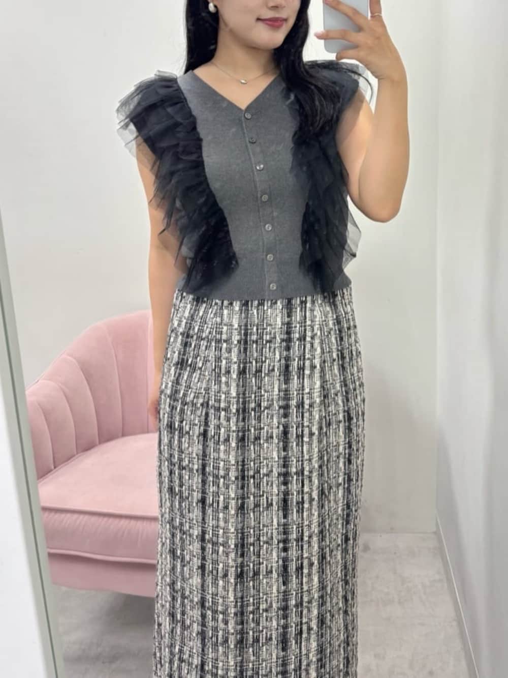 グレー系のスカート、ブラック系のブーツ、グレー系のベストを着用したレディースの秋コーディネートの5枚目の写真