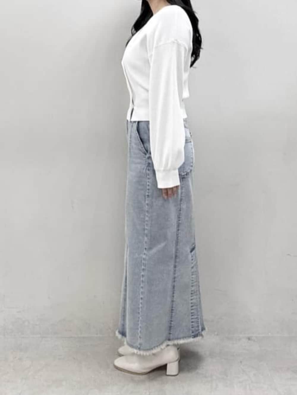 ブルー系のデニムスカート、ホワイト系のカーディガン/ボレロを着用したレディースの冬コーディネートの2枚目の写真