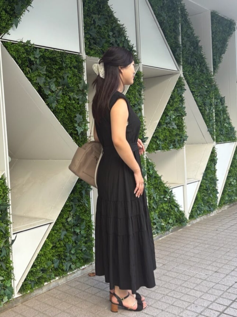 ベージュ系のボストンバッグ、ブラック系のワンピースを着用したレディースの秋コーディネートの3枚目の写真