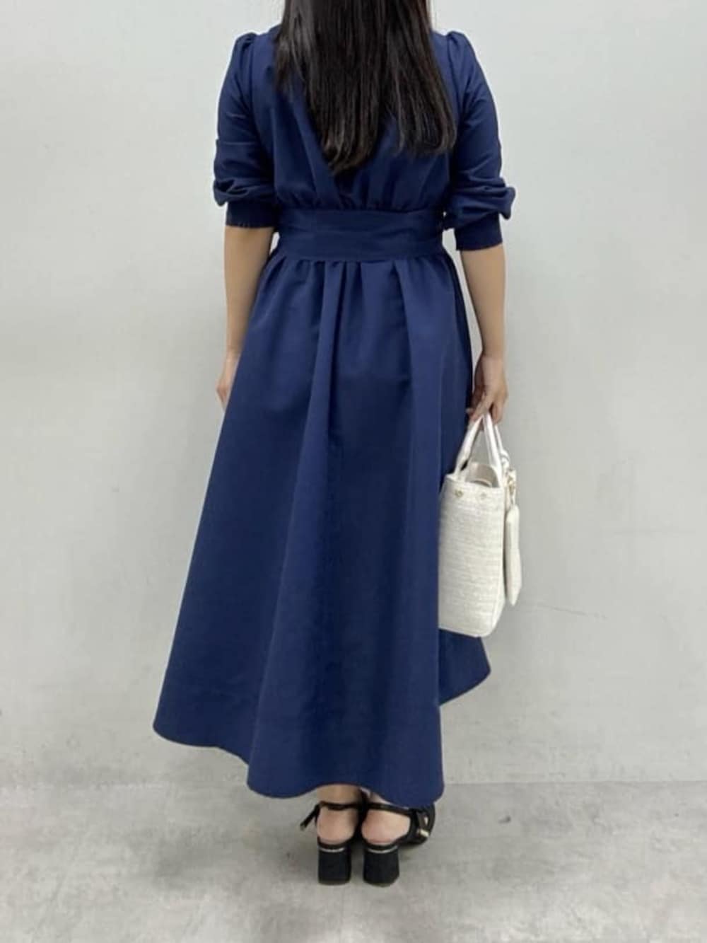 ブラック系のサンダル、ホワイト系のハンドバッグ、ブルー系のワンピースを着用したレディースの冬コーディネートの3枚目の写真