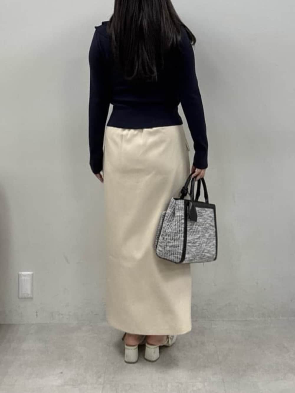 ホワイト系のサンダル、ブルー系のカーディガン/ボレロ、ブラック系のハンドバッグを着用したレディースの冬コーディネートの3枚目の写真