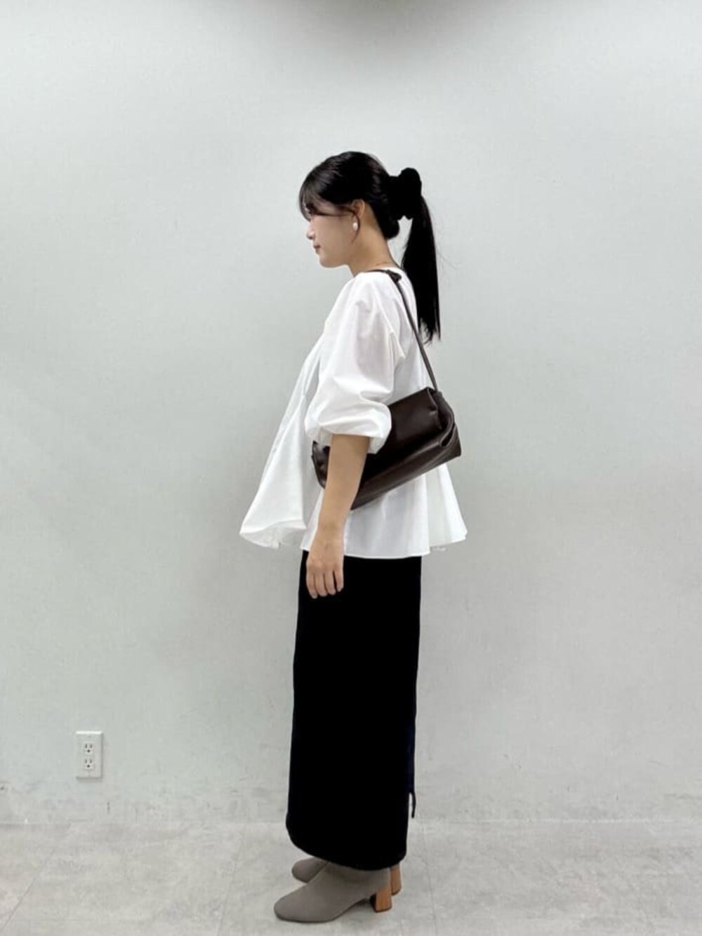 ブルー系のスカート、ホワイト系のシャツ/ブラウスを着用したレディースの秋コーディネートの2枚目の写真