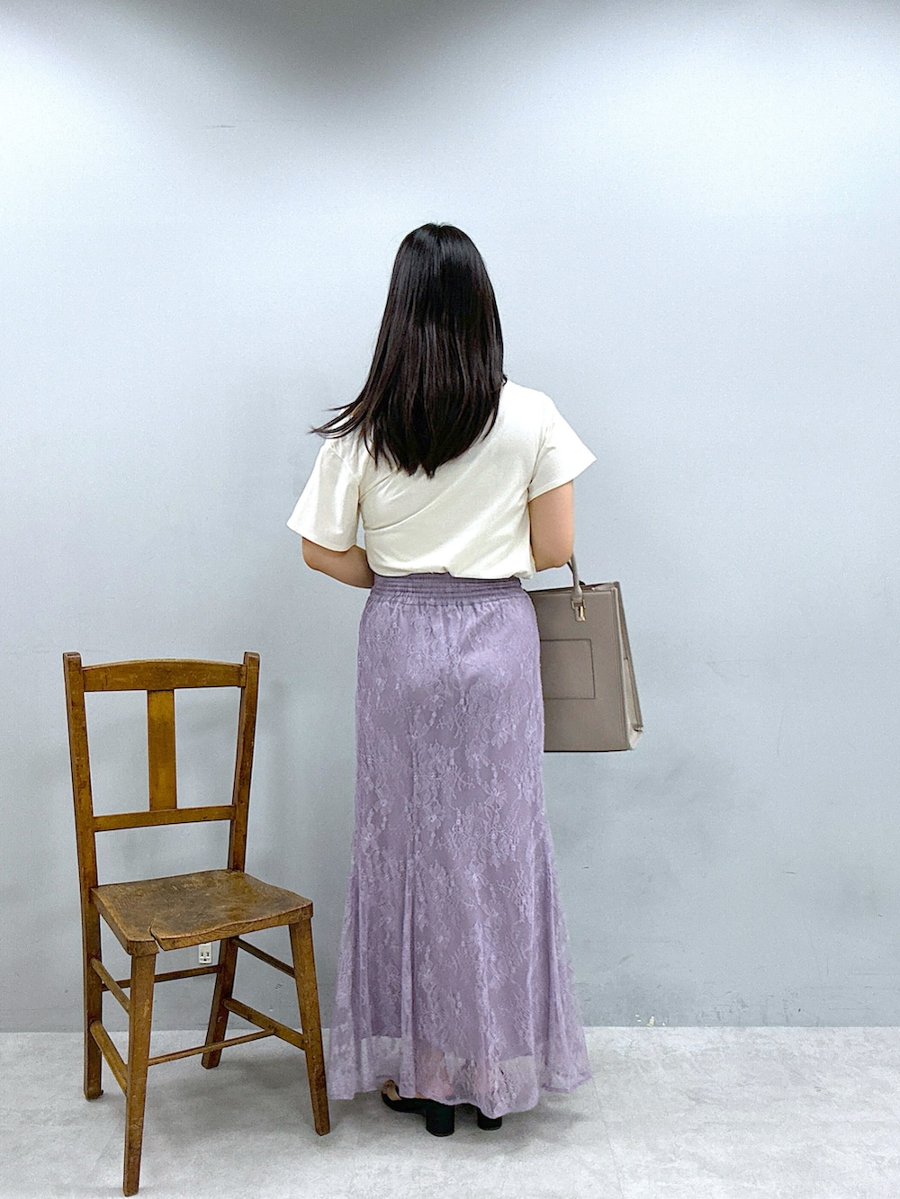 ベージュ系のショルダーバッグ、パープル系のスカート、ホワイト系のTシャツ/カットソーを着用したレディースの春コーディネートの3枚目の写真