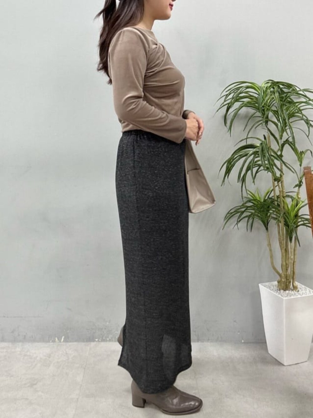 ブラック系のスカート、ベージュ系のTシャツ/カットソーを着用したレディースの夏コーディネートの2枚目の写真