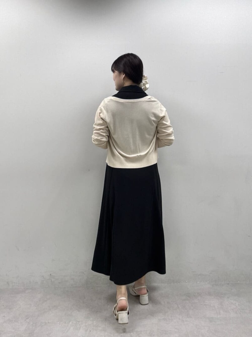 ブラック系のワンピース、ホワイト系のカーディガン/ボレロを着用したレディースの春コーディネートの4枚目の写真