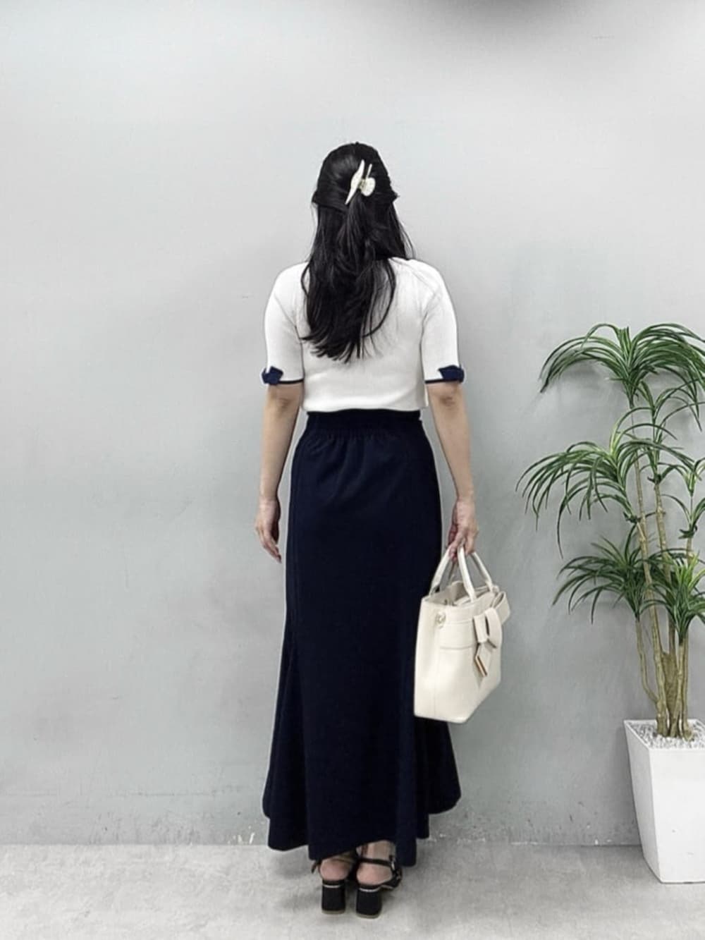 ホワイト系のニット/セーターを着用したレディースの春コーディネートの2枚目の写真