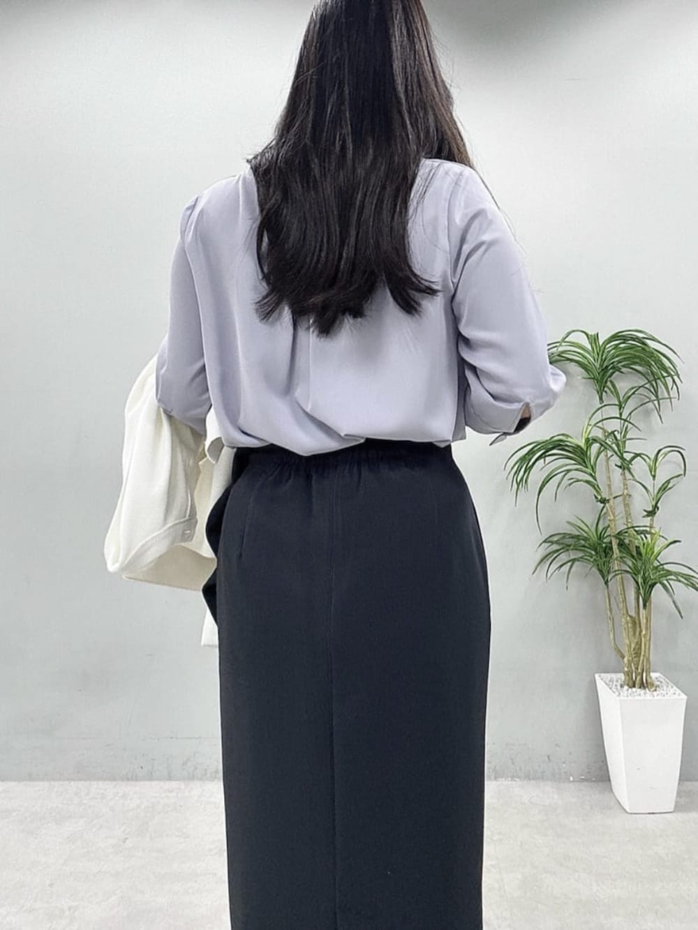 ブラック系のスカート、ホワイト系のカーディガン/ボレロ、ブルー系のシャツ/ブラウスを着用したレディースの春コーディネートの6枚目の写真