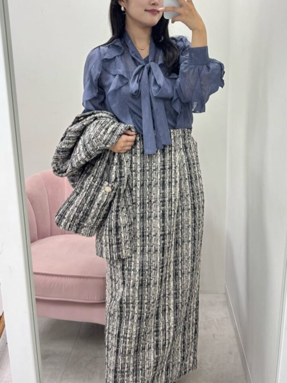 グレー系のスカート、グレー系のノーカラージャケット、ブルー系のシャツ/ブラウスを着用したレディースの秋コーディネートの2枚目の写真