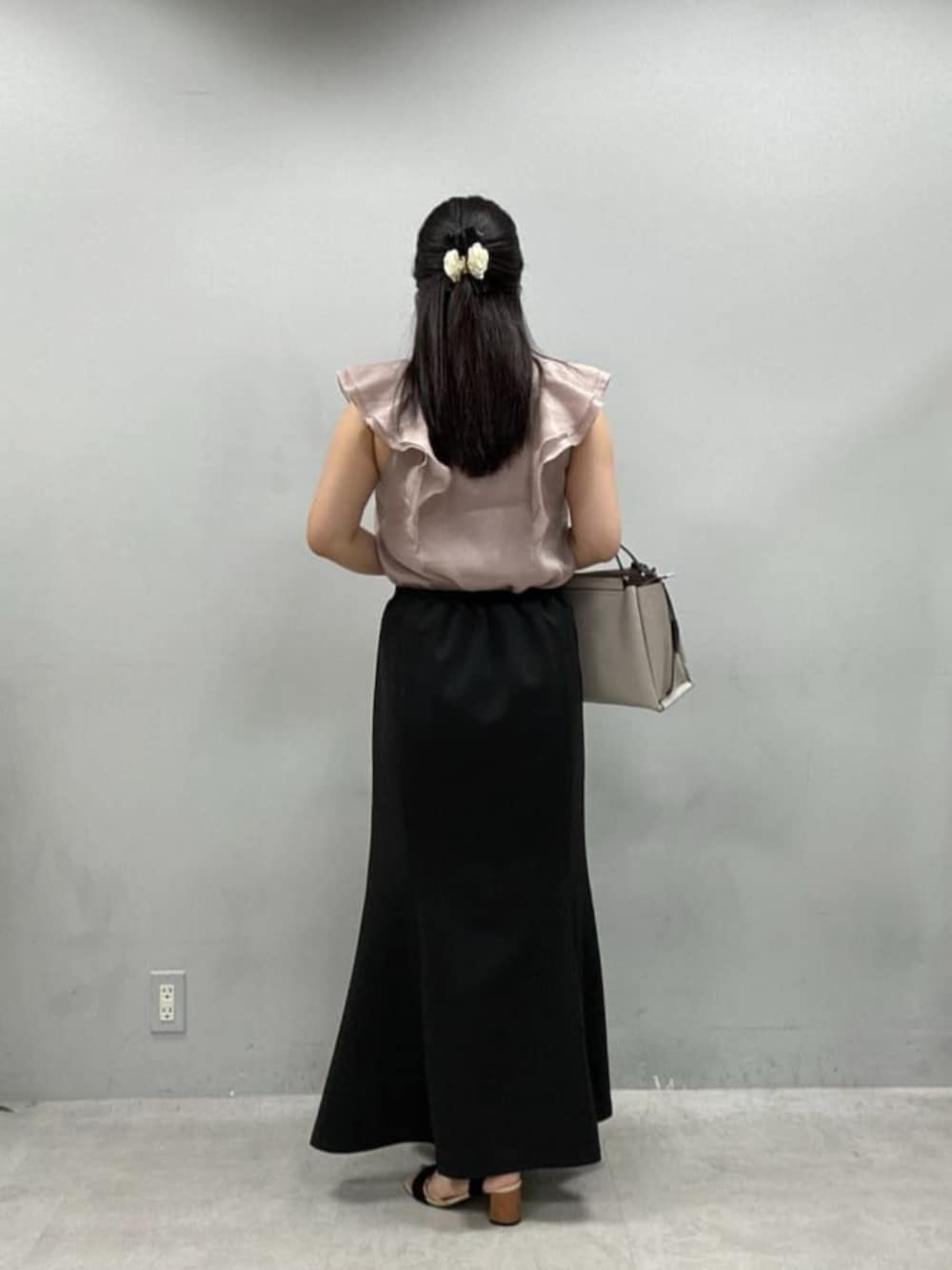 ブラック系のスカート、ピンク系のシャツ/ブラウスを着用したレディースの夏コーディネートの3枚目の写真