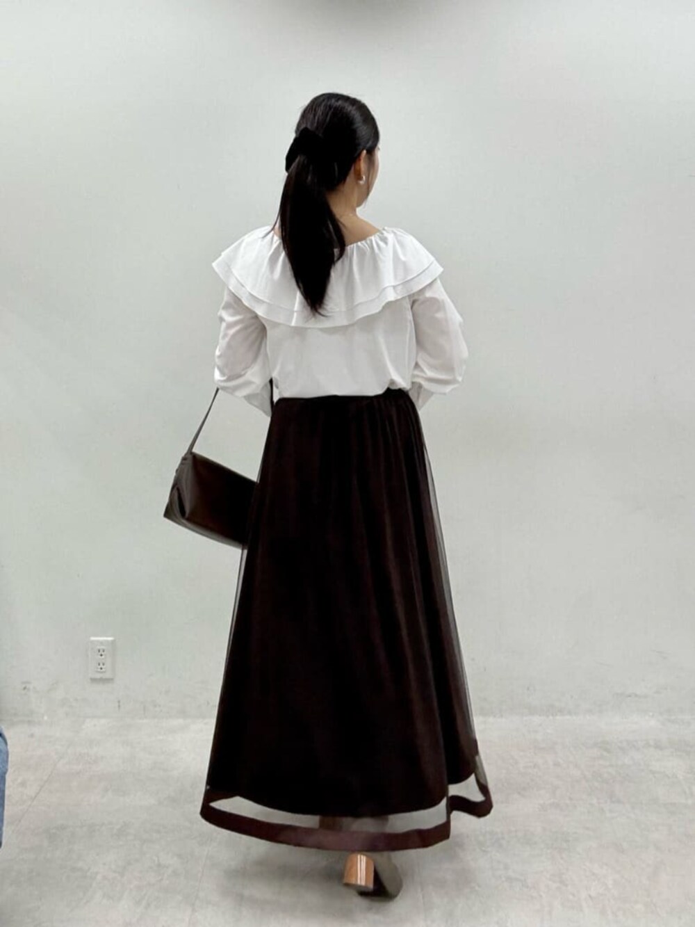 ブラウン系のスカート、グレー系のテーラードジャケットを着用したレディースの秋コーディネートの8枚目の写真