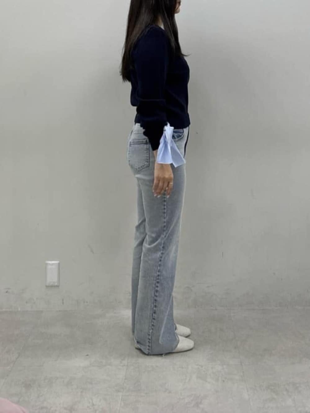 ブルー系のデニムパンツ、ホワイト系のサンダル、ブルー系のカーディガン/ボレロを着用したレディースの冬コーディネートの2枚目の写真