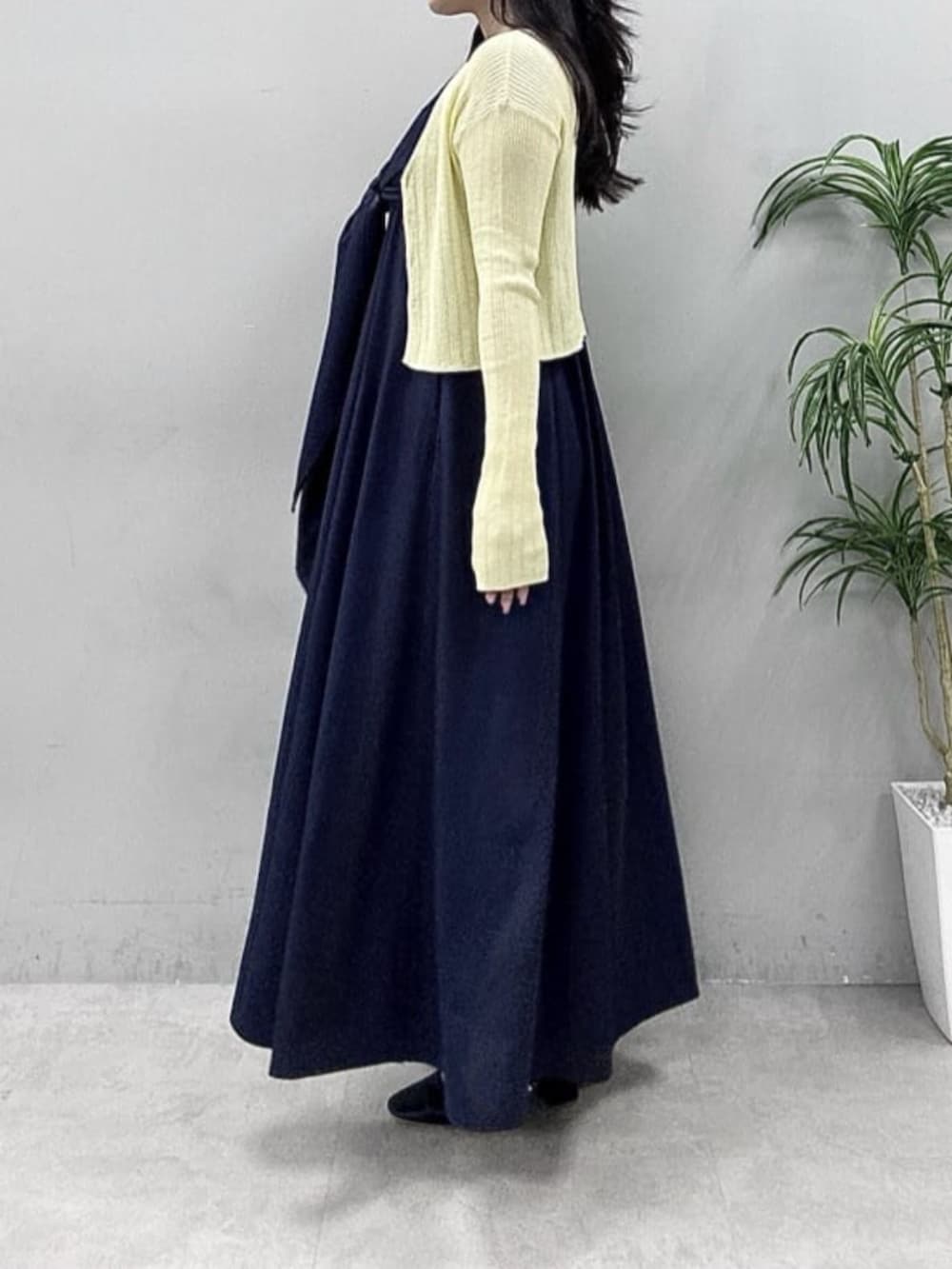 イエロー系のカーディガン/ボレロ、ブルー系のワンピースを着用したレディースの春コーディネートの2枚目の写真