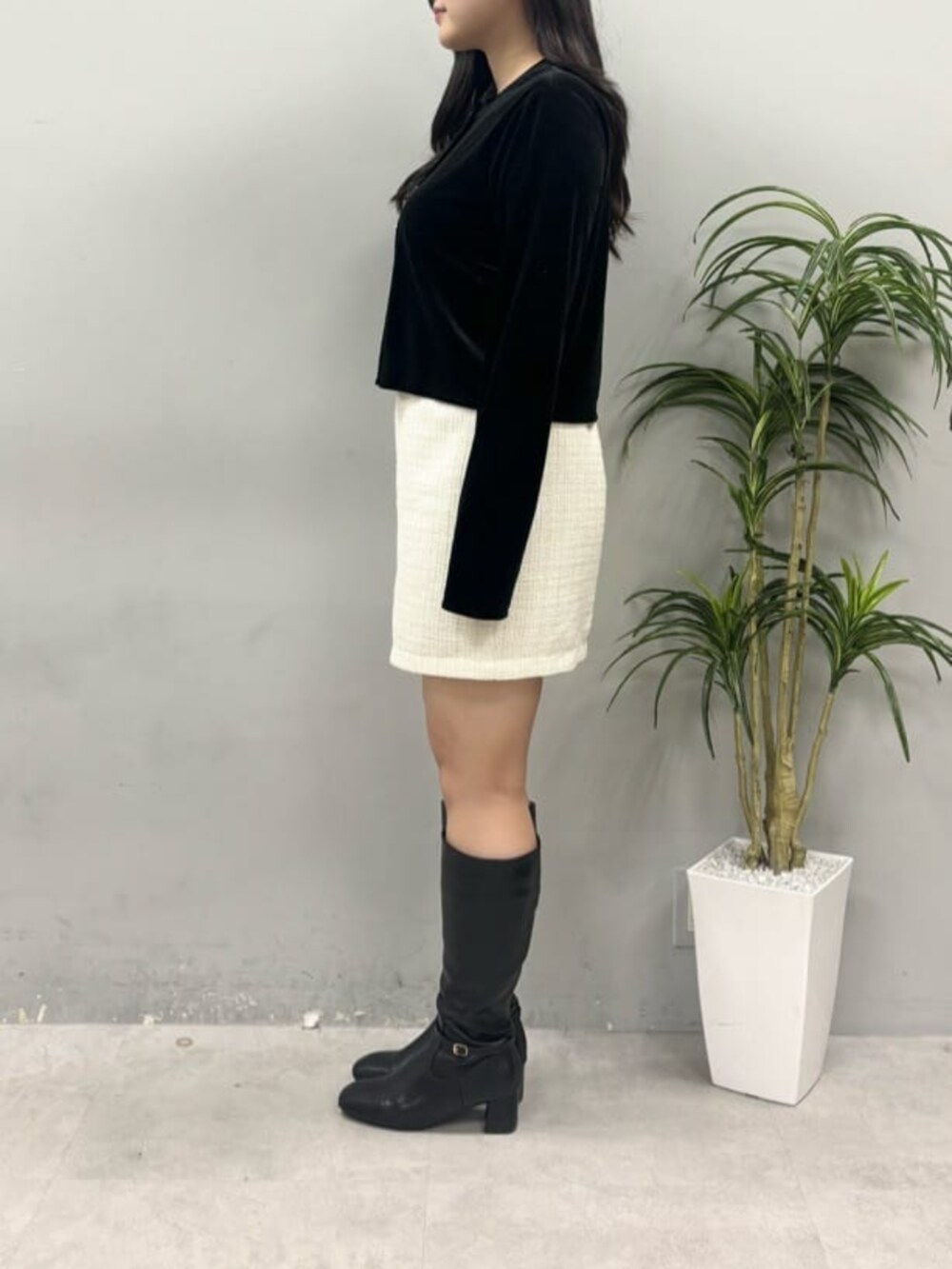 ホワイト系のスカート、ブラック系のカーディガン/ボレロを着用したレディースの冬コーディネートの2枚目の写真