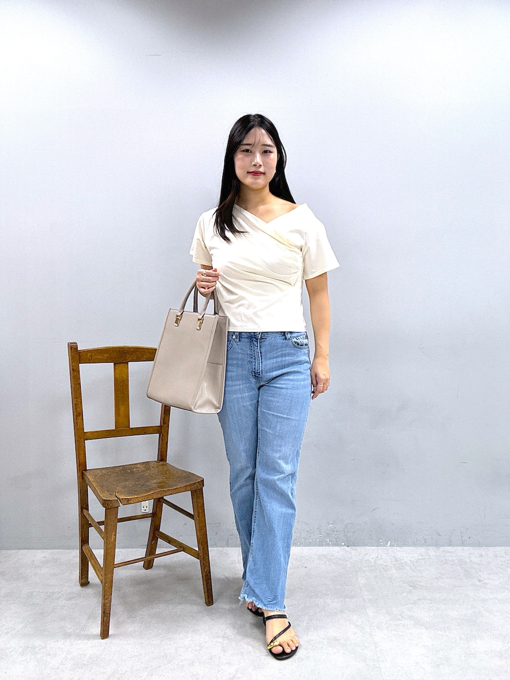 ベージュ系のショルダーバッグ、パープル系のスカート、ホワイト系のTシャツ/カットソーを着用したレディースの春コーディネートの4枚目の写真