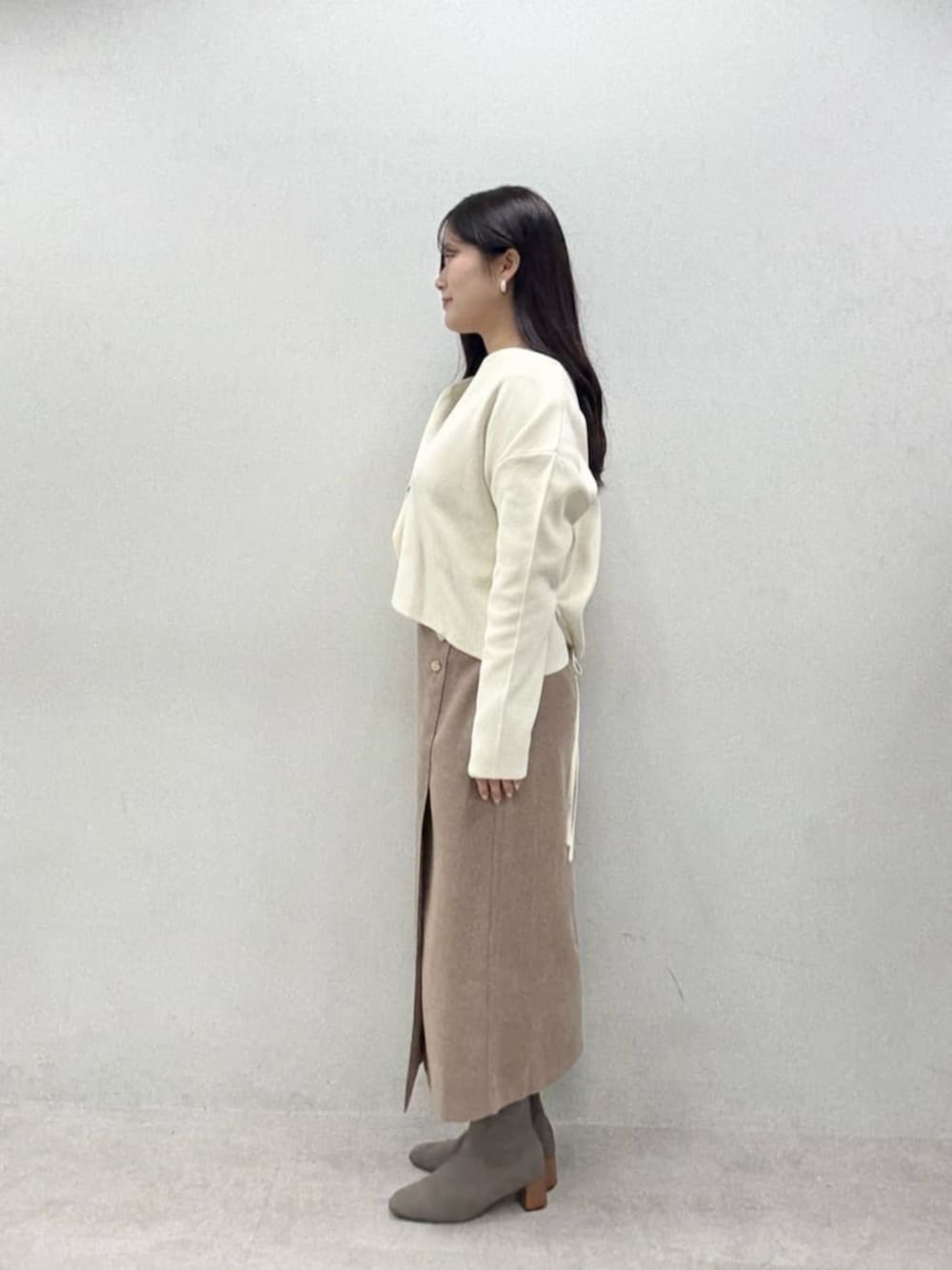 ブラウン系のスカート、グレー系のTシャツ/カットソー、ホワイト系のカーディガン/ボレロを着用したレディースの秋コーディネートの5枚目の写真