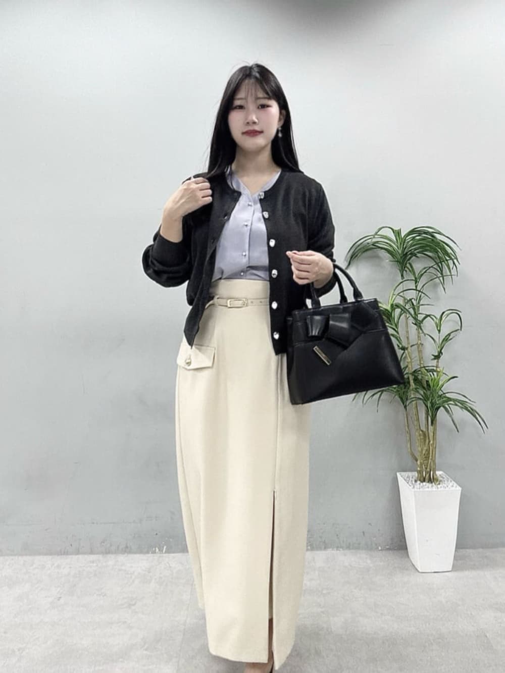 ホワイト系のスカート、ブルー系のシャツ/ブラウス、グレー系のカーディガン/ボレロを着用したレディースの春コーディネートの3枚目の写真