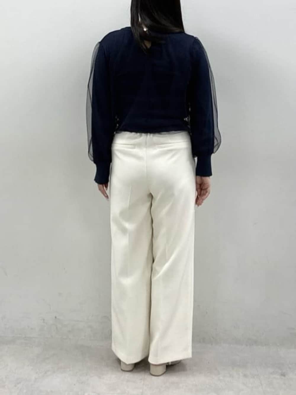 ホワイト系のスラックス、ブルー系のニット/セーターを着用したレディースの春コーディネートの3枚目の写真