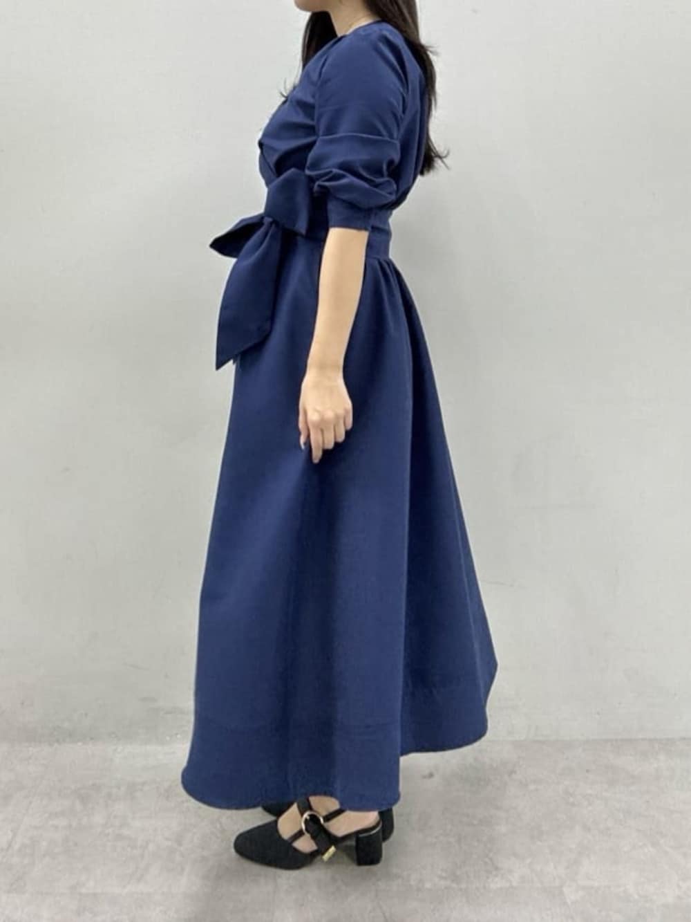 ブラック系のサンダル、ホワイト系のハンドバッグ、ブルー系のワンピースを着用したレディースの冬コーディネートの2枚目の写真