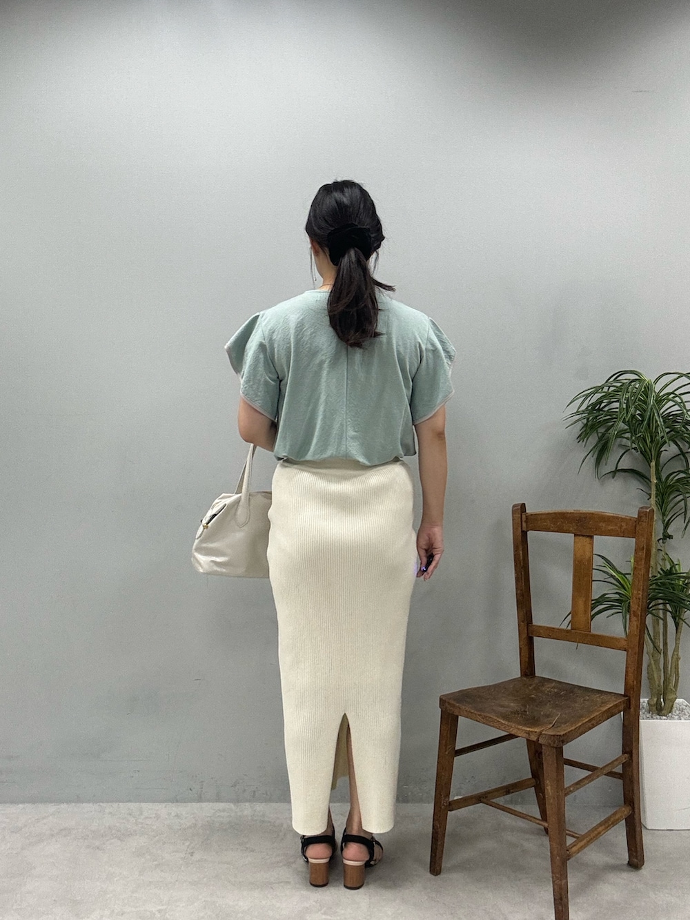 ホワイト系のショルダーバッグ、グリーン系のTシャツ/カットソー、ホワイト系のスカートを着用したレディースの春コーディネートの5枚目の写真