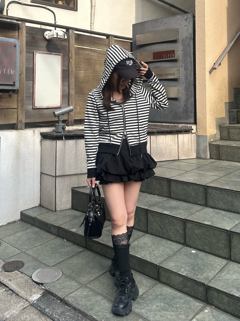 ブラック系のスカート、ブラック系のショルダーバッグ、ブラック系のソックス/靴下を着用したレディースの春コーディネートの3枚目の写真