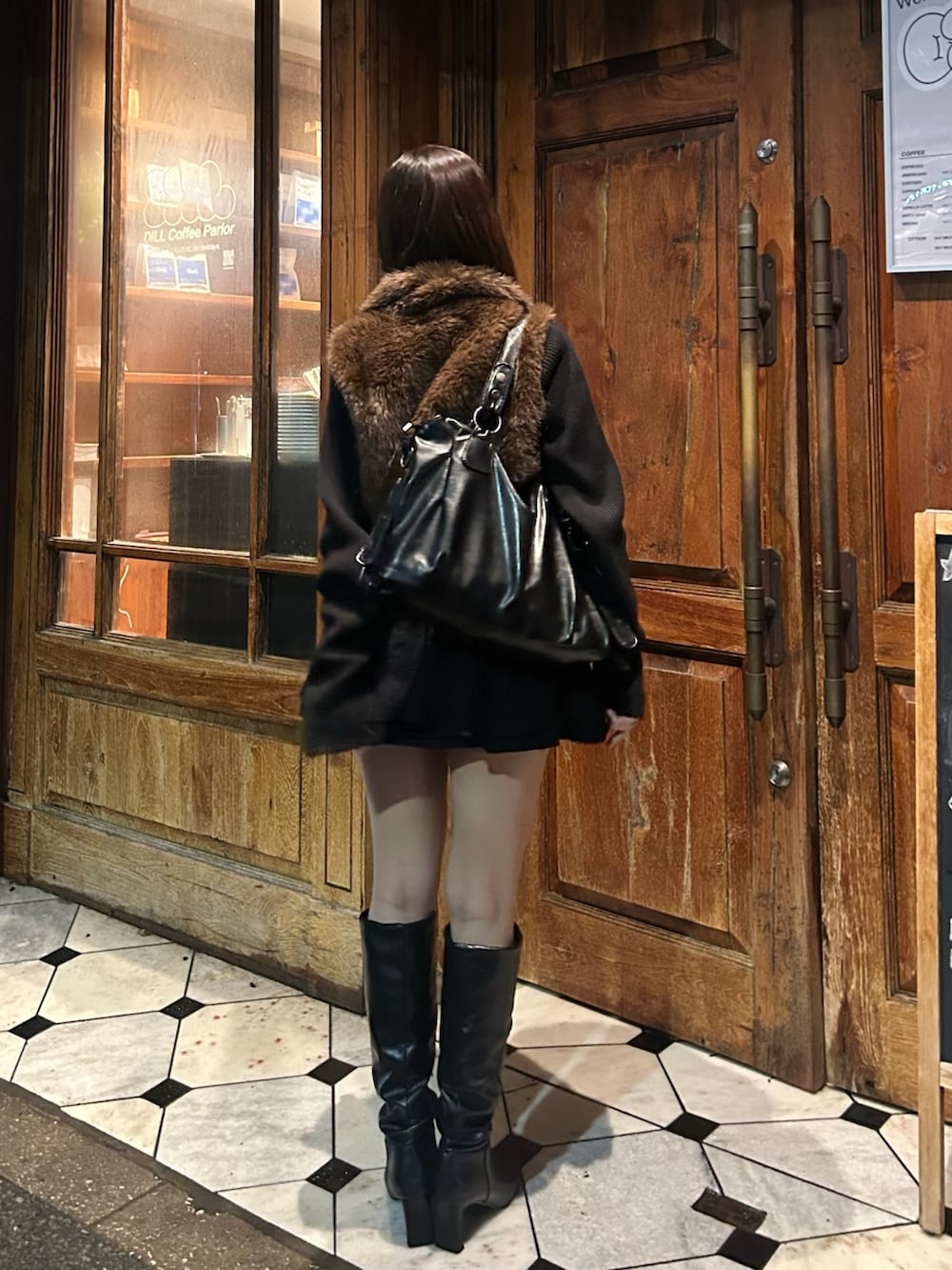 ブラック系のニット/セーターを着用したレディースの秋コーディネートの2枚目の写真