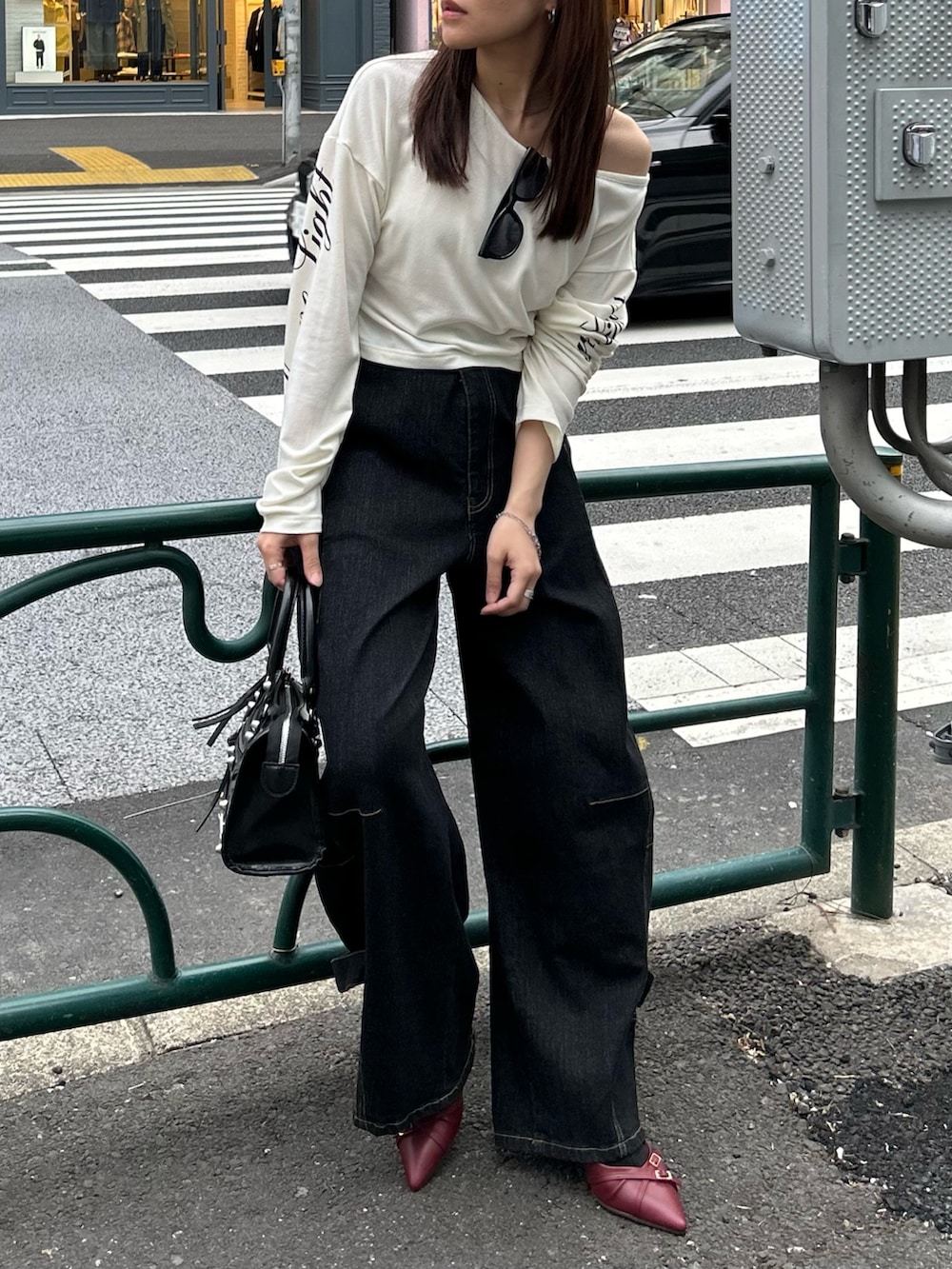 ホワイト系のTシャツ/カットソー、ブラック系のデニムパンツ、ブラック系のショルダーバッグを着用したレディースの春コーディネートの8枚目の写真