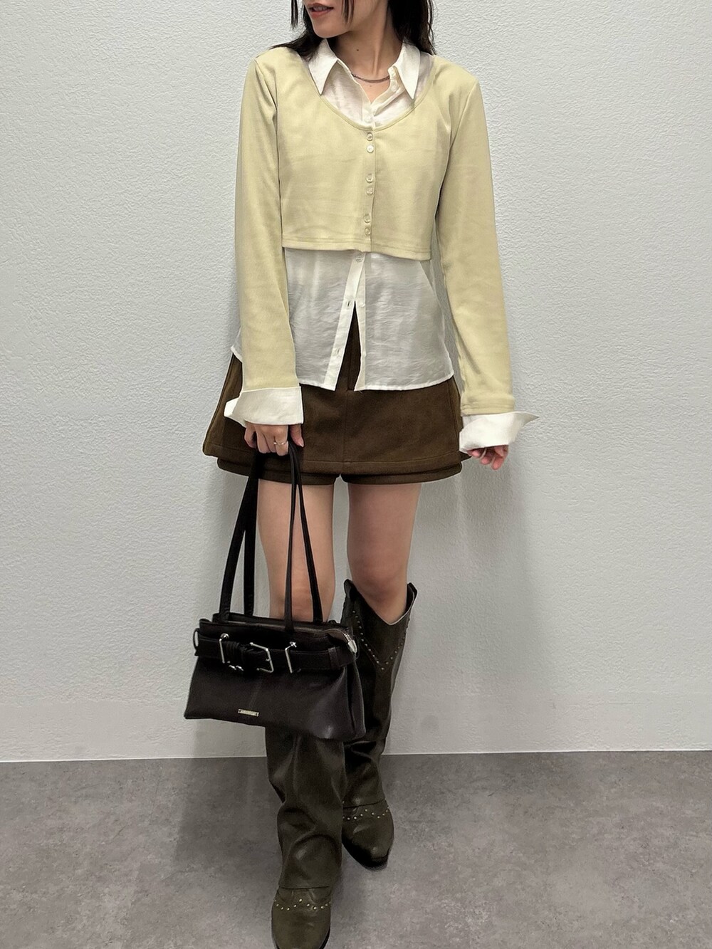 ブラウン系のスカート、ベージュ系のカーディガン/ボレロを着用したレディースの秋コーディネートの2枚目の写真