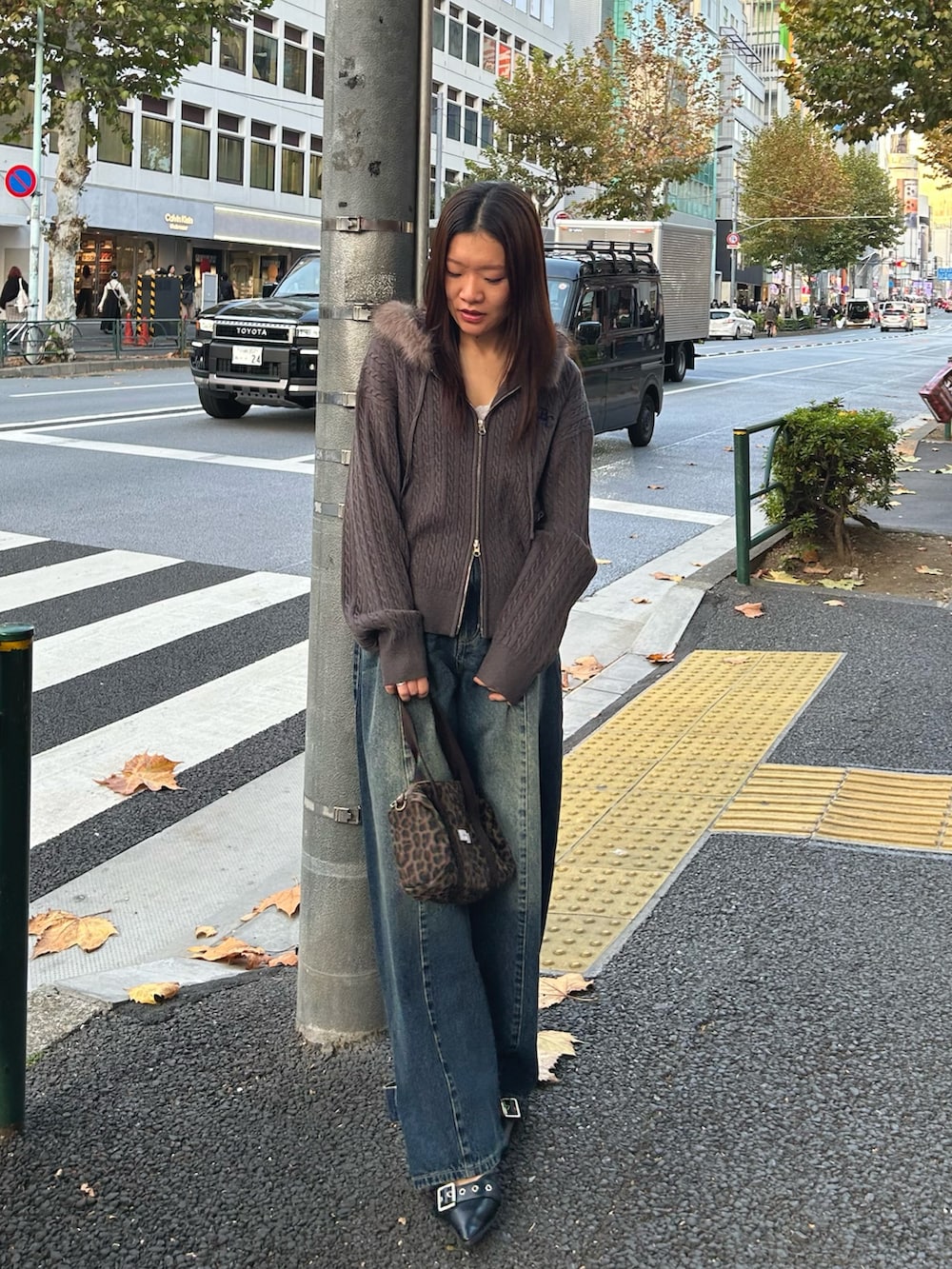 グレー系のパーカー、ブルー系のデニムパンツを着用したレディースの冬コーディネートの4枚目の写真