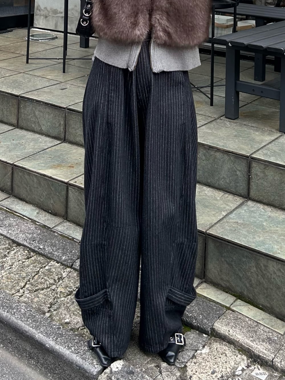 ブラウン系のニット/セーター、ブルー系のデニムパンツ、ブラック系のショルダーバッグを着用したレディースの秋コーディネートの5枚目の写真
