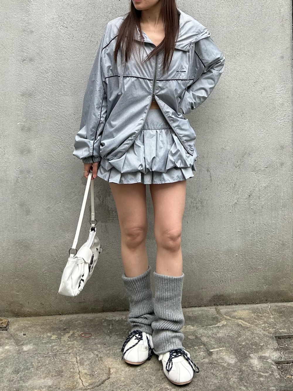 グレー系のブルゾン、グレー系のスカート、ホワイト系のスニーカーを着用したレディースの春コーディネートの3枚目の写真