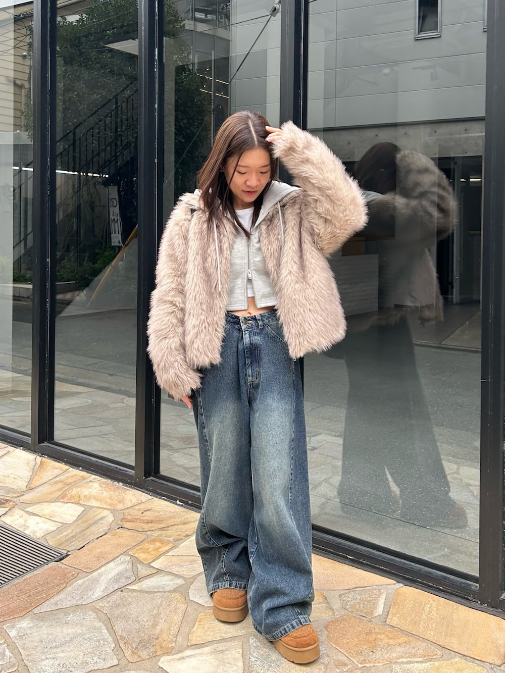 ブルー系のデニムパンツ、ブラック系のトートバッグ、イエロー系のブーツを着用したレディースの秋コーディネートの2枚目の写真