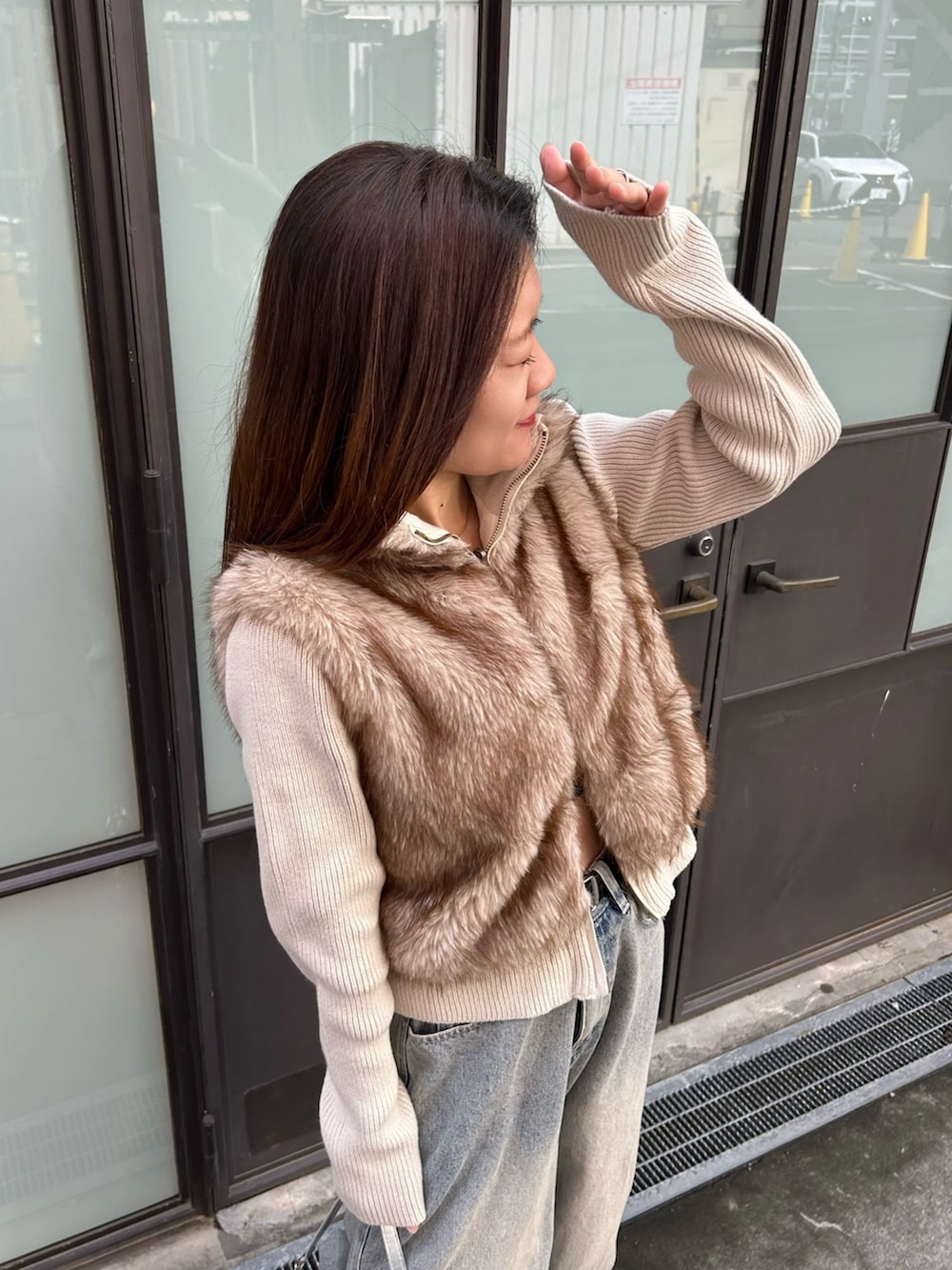 ベージュ系のニット/セーター、シルバー系のショルダーバッグを着用したレディースの秋コーディネートの5枚目の写真