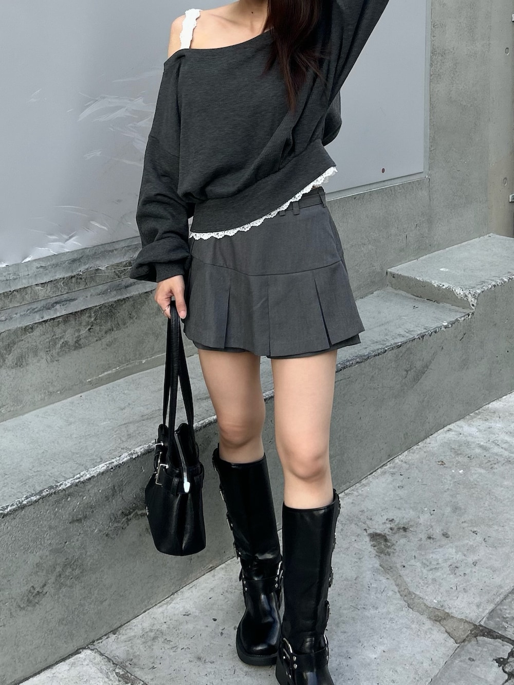 グレー系のスウェット、グレー系のスカート、ブラック系のブーツを着用したレディースの秋コーディネートの4枚目の写真