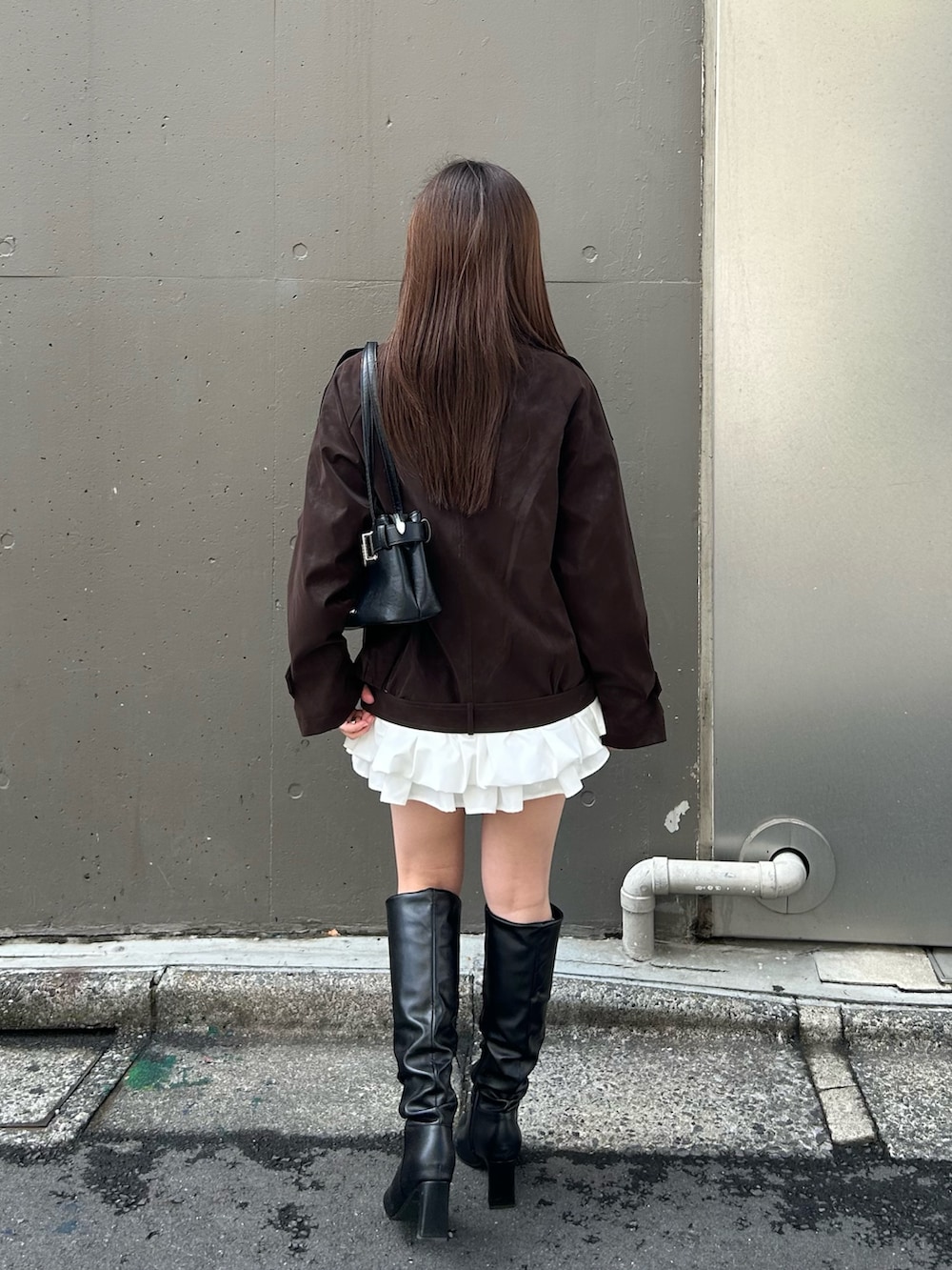 ブラウン系のトレンチコートを着用したレディースの春コーディネートの2枚目の写真