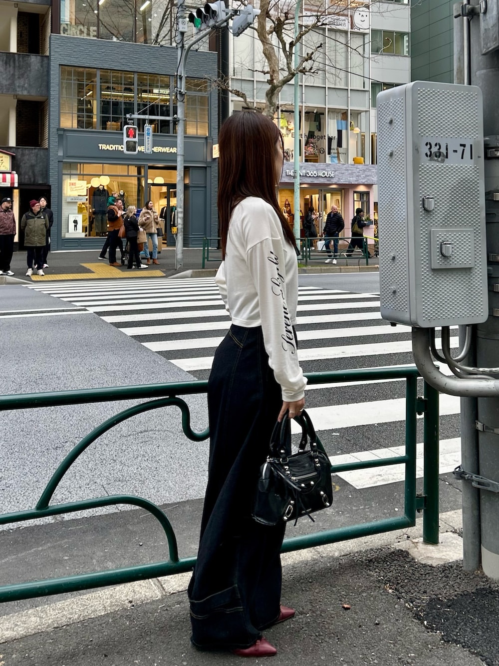 ホワイト系のTシャツ/カットソー、ブラック系のデニムパンツ、ブラック系のショルダーバッグを着用したレディースの春コーディネートの6枚目の写真